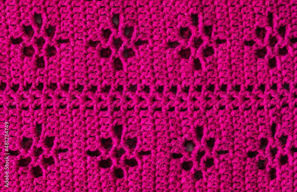 Knitted cotton texture. Crocheted pink floral pattern.