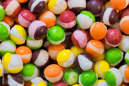Freeze dried Skittles hard candy split centers, colorful sweet food treat background.