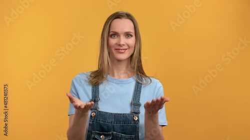 Portrait lady coming here gesture friendly welcome joining to her posing isolated on orange studio 
