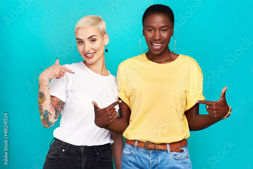Speak your truth. Studio shot of two confident young women pointing at their t shirts against a turquoise background. photo