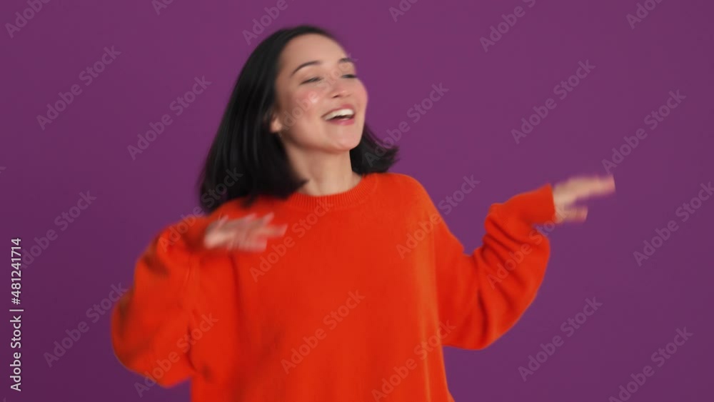 Happy woman in red sweater dancing in the purple studio Happy woman in red sweater dancing in the purple studio
