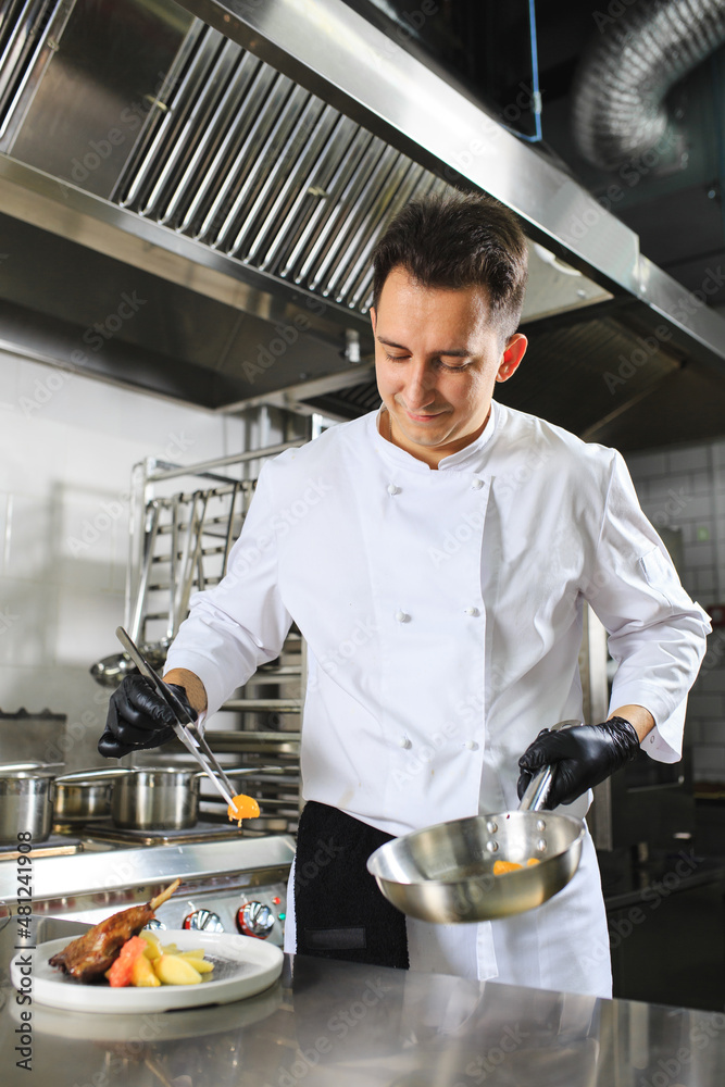 Chef Preparing Dish In Kitchen. Decorating Dish.