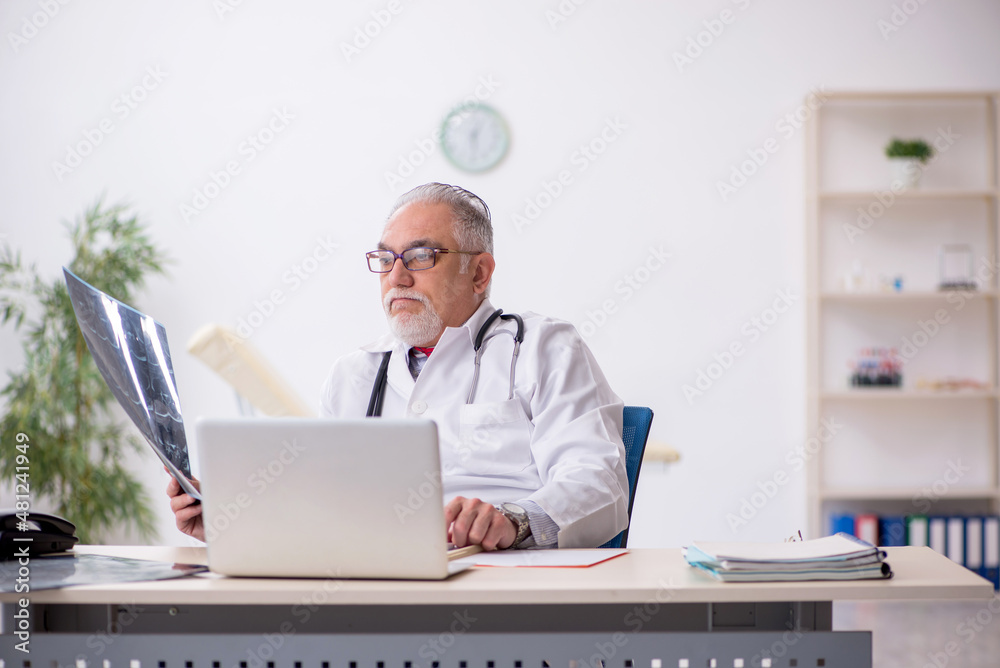 Old male doctor radiologist working in the clinic
