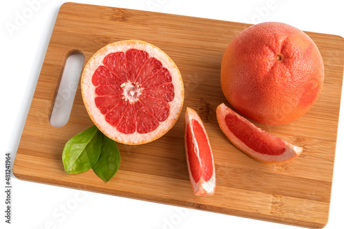 Ripe orange grapefruit whole and sliced on a wooden cutting board with leaves.Isolated on a white background. 