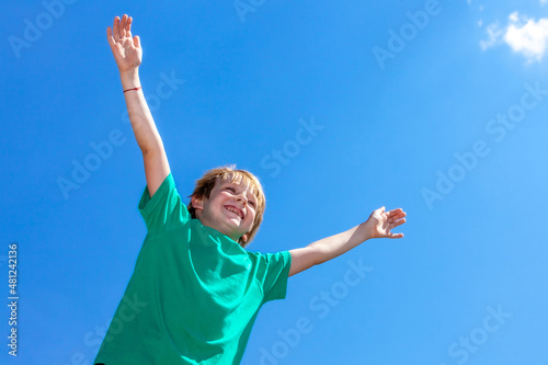 happy little boy against the blue sky