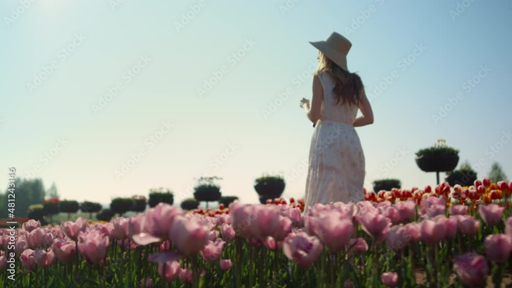 Elegant lady spending time in nature. Romantic woman smiling in flowers garden.