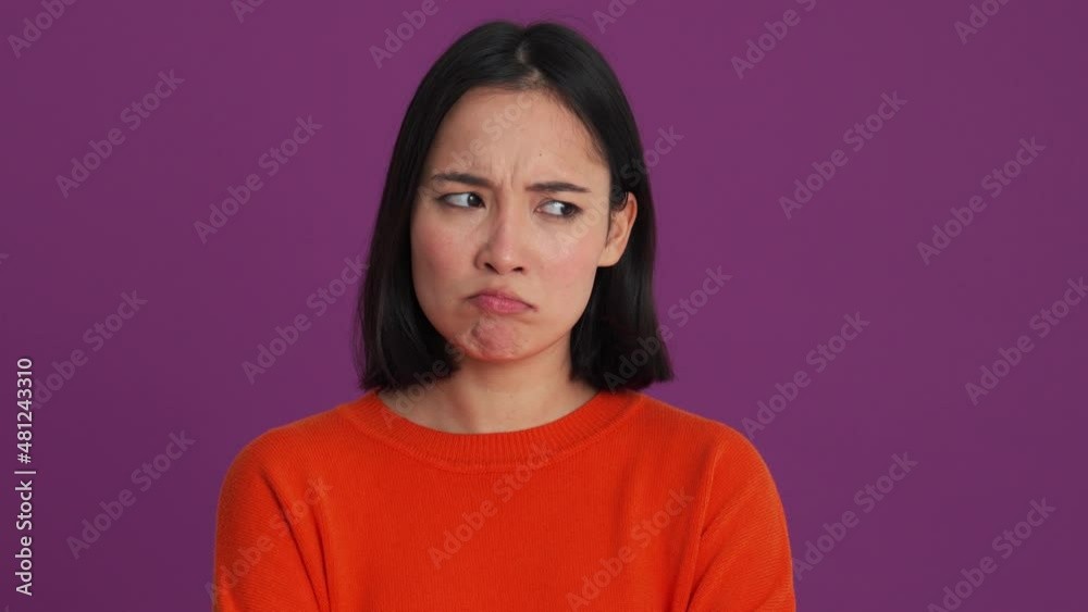 Offended woman in red sweater looking to the side in the purple studio Offended woman in red sweater looking to the side in the purple studio