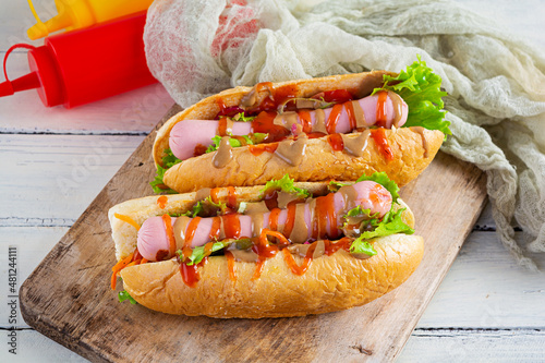 Delicious hot dog with ketchup and mustard on wooden background. Street food