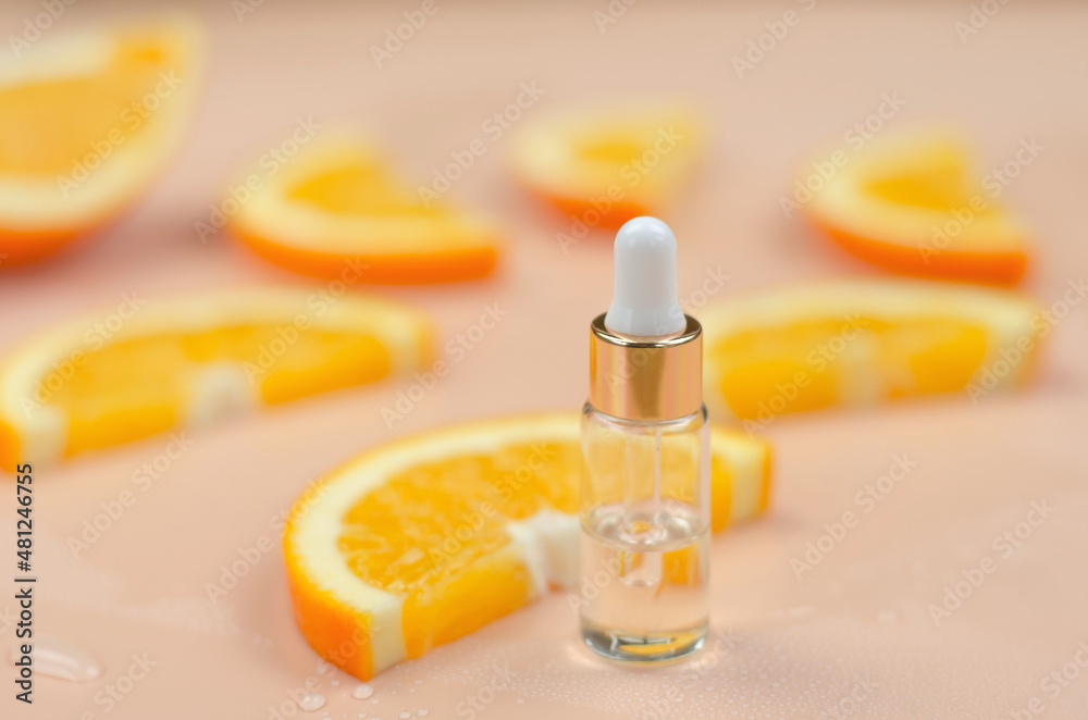 Orange oil in a bottle with a dropper and orange slices, selective focus