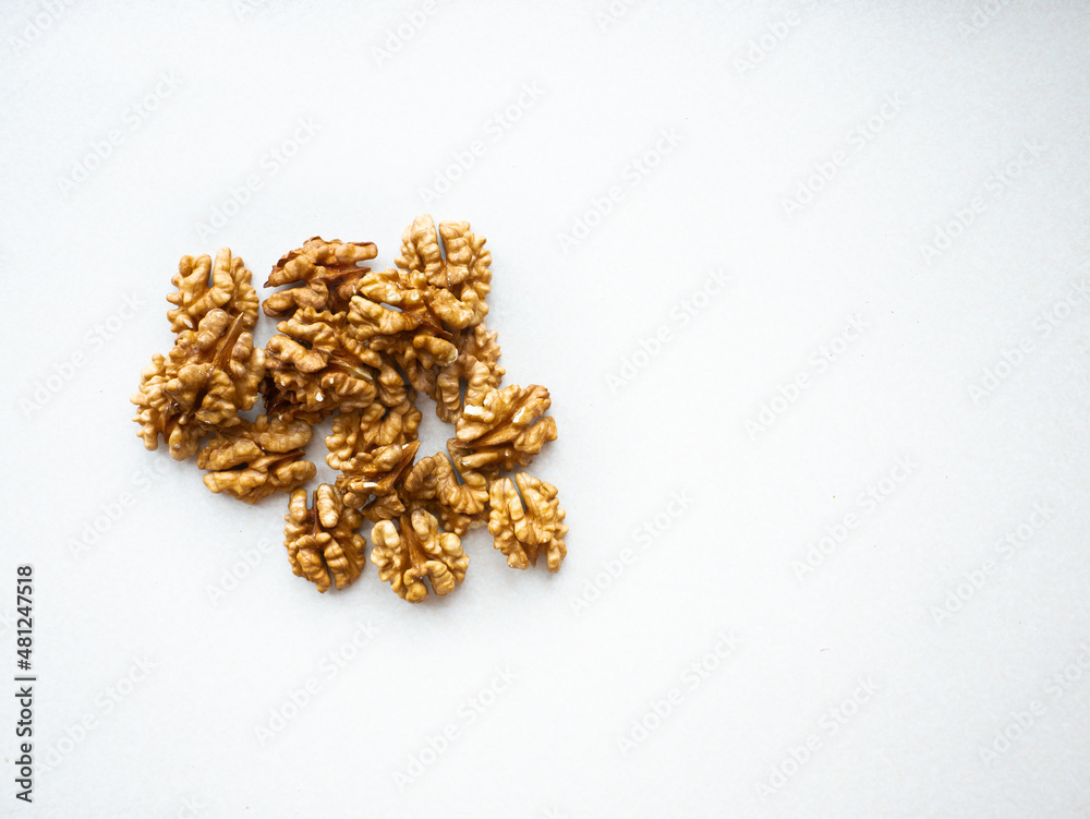 Walnut scattered on a white background. Peeled walnut kernels Walnut scattered on a white background. Peeled walnut kernels