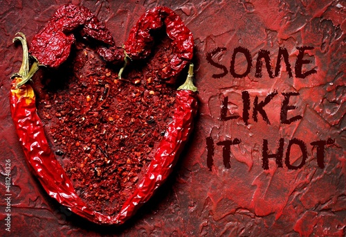 Valentine's day card with the inscription "some like it hot". heart of hot chili peppers on a red background.