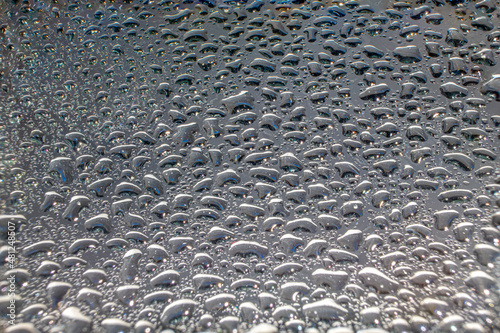 Water droplets on a glass in form of lenses with a colourful background. Wallpaper for screen. Abstract background.