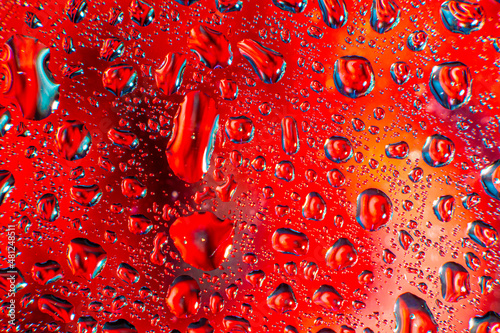 Water droplets on a glass in form of lenses with a colourful background. Wallpaper for screen. Abstract background.