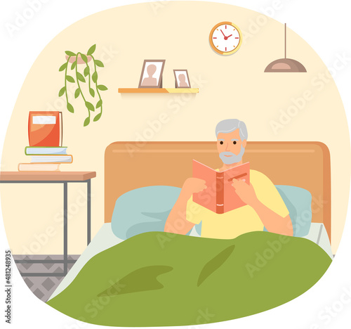 Cute man in pajamas reading literature on his bed comfortably. Book lover concept with young man lying relax on sofa and reading book. Concept of homeward and comfort. Person relaxes after work