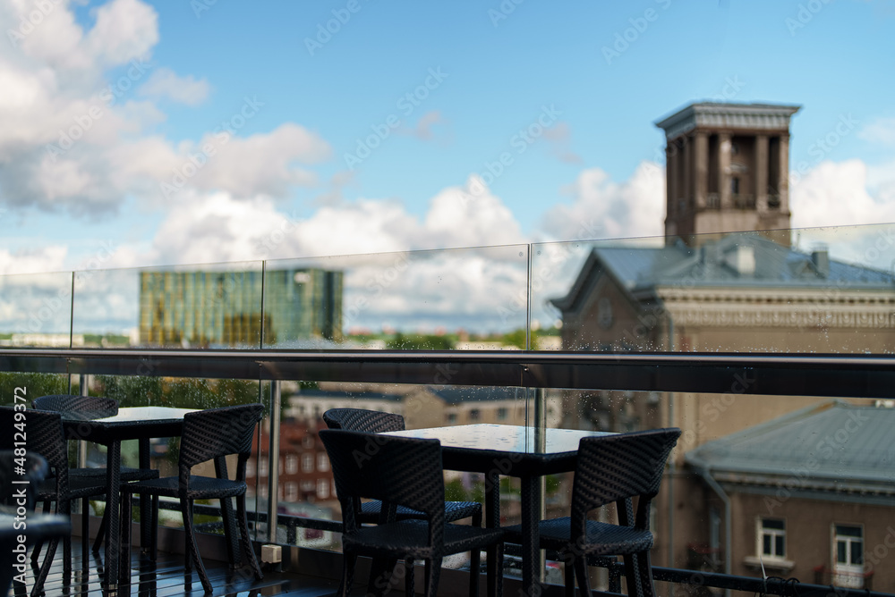 Obraz premium Rooftop cafe interior with table and chairs.