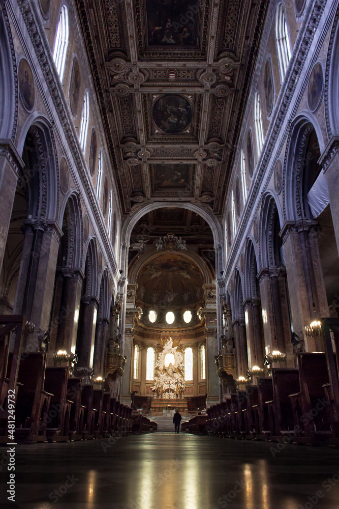 interior of a basilica, shot from low angle and a person is walking in distance