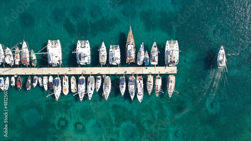Aerial drone top down photo of exotic island marina with emerald clear sea a safe anchorage for yachts and sailboats