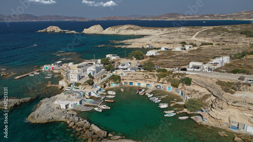 Aerial drone photo of picturesque small fishing harbour of Mandrakia with traditional boat houses called syrmata and anchored fishing boats, Milos island, Cyclades, Greece