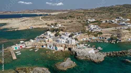 Aerial drone photo of picturesque small fishing harbour of Mandrakia with traditional boat houses called syrmata and anchored fishing boats, Milos island, Cyclades, Greece photo