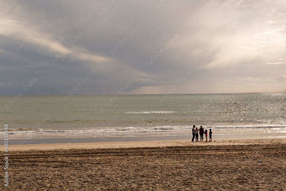 Familia en la playa al atardecer en un día de otoño. Familia en la playa al atardecer en un día de otoño.