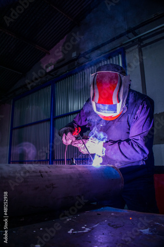 welder operator  welding with electric arc welder and white mask