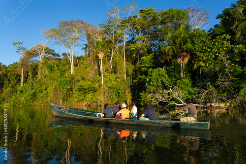 A boat with tourist and water reflections in  amazon jungle, puerto maldonado, Peru photo