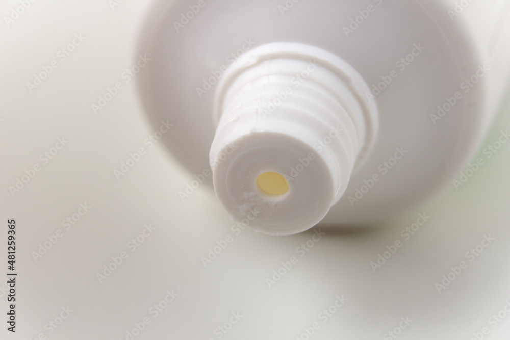 The white tube of toothpaste is open. The thread of the neck of a white tube close-up. The white tube of toothpaste is open. The thread of the neck of a white tube close-up.