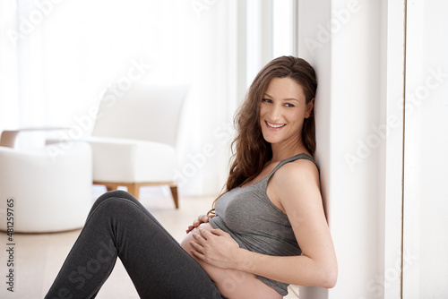 Beautifully pregnant. Cropped shot of a young pregnant woman sitting in her home. Free Download Beautifully pregnant. Cropped shot of a young pregnant woman sitting in her home. - GFXLoad