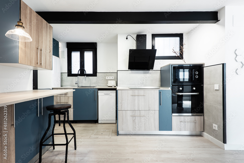 Kitchen with black appliances, combined indigo blue and light wood furniture with black metal beam Kitchen with black appliances, combined indigo blue and light wood furniture with black metal beam