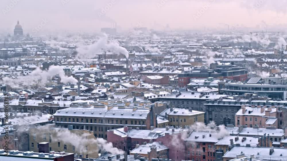 Winter panorama of the city. Rofftops in snow. Steam from pipes Winter panorama of the city. Rofftops in snow. Steam from pipes
