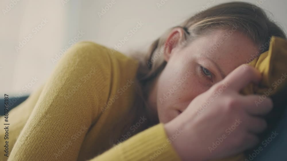 Lonely young female lying on bed, emotions of helplessness in sad eyes, crisis