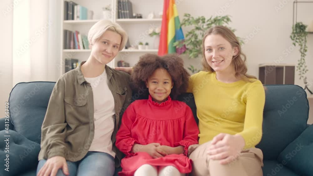 Happy lesbian couple sitting couch with adopted black daughter, lgbt parenting Happy lesbian couple sitting couch with adopted black daughter, lgbt parenting