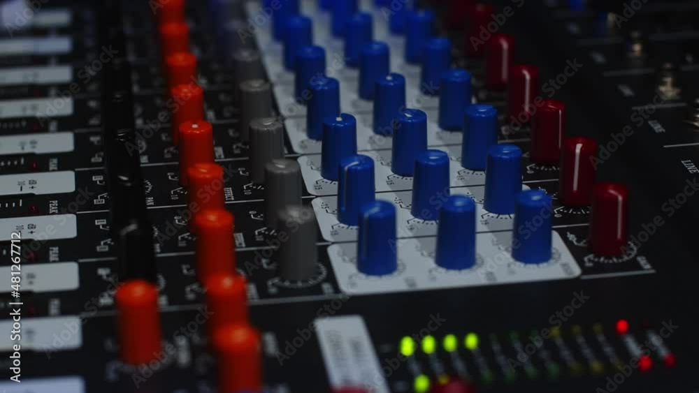 Sound engineer raises the volume of music at a party using a professional mixer Sound engineer raises the volume of music at a party using a professional mixer