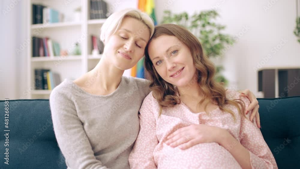 Happy pregnant lgbt couple hugging and looking at camera, donor insemination Happy pregnant lgbt couple hugging and looking at camera, donor insemination