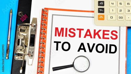 Mistakes to avoid. The inscription in the planning folder, on the background of a calculator, magnifying glass and a pen for writing.