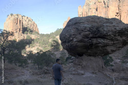 Latino adult man with hat and camera explores and discovers the great rock formations of Sierra de Organos in Zacatecas Mexico 