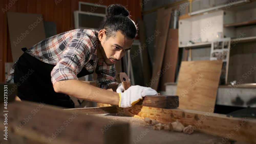 Young Asian man carpenters are using spokeshave to decorate the woodwork. Young Asian man carpenters are using spokeshave to decorate the woodwork.