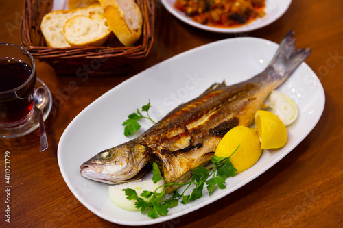 Delicious fish dish, fried bass served with onion, lemon and parsley. Turkish cuisine