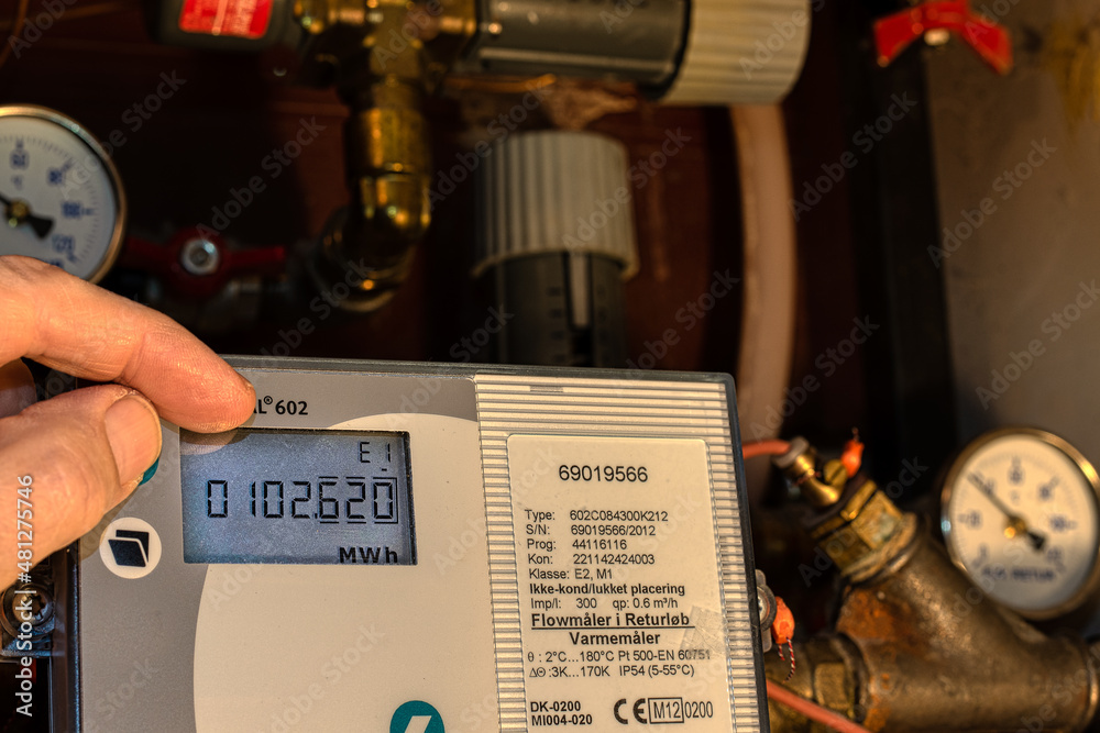 two fingers control the digital meter of the district heating to save energy