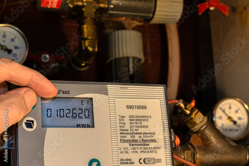 Obraz na płótnie two fingers control the digital meter of the district heating to save energy w salonie