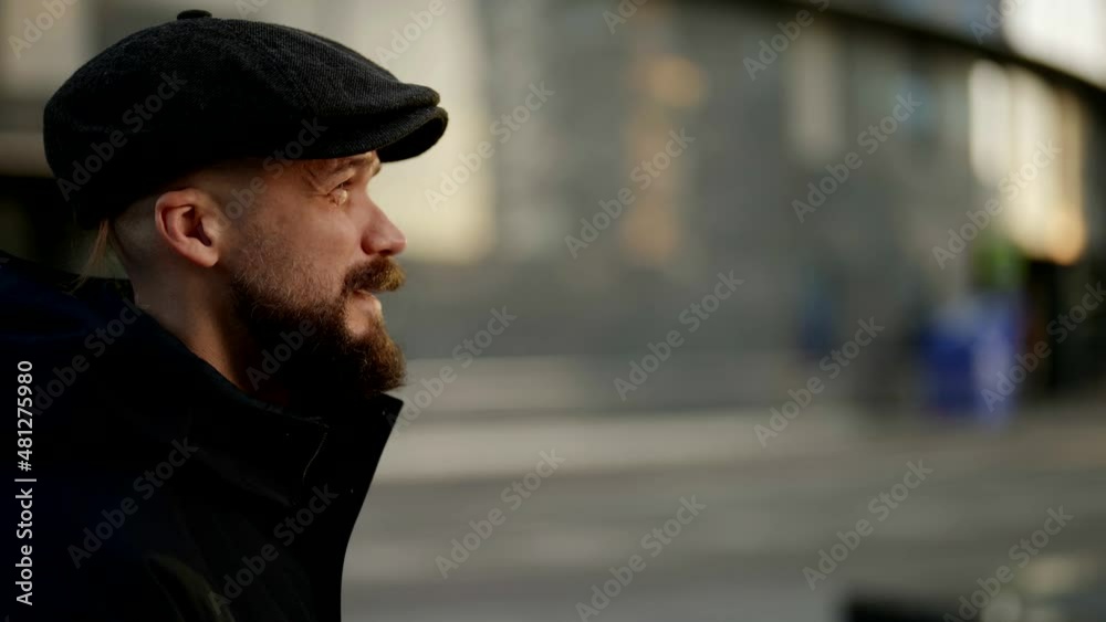 portrait in profile of a mustachioed and bearded man in a cap against the background of a blurred city street. the camera is moving portrait in profile of a mustachioed and bearded man in a cap against the background of a blurred city street. the camera is moving