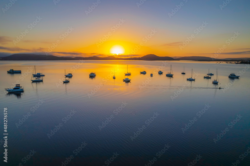 Sunrise waterscape with boats, soft clouds and reflections Sunrise waterscape with boats, soft clouds and reflections