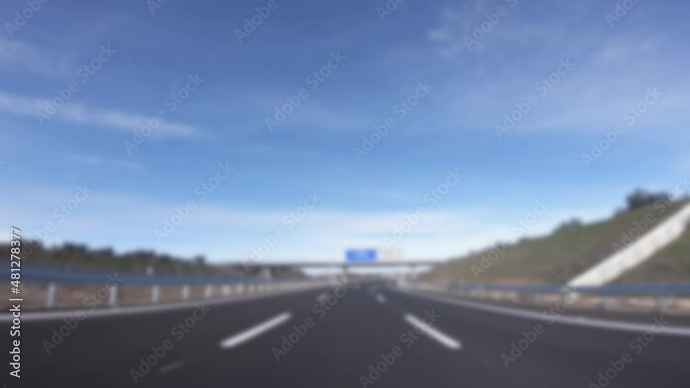 Blurred defocused POV view of car driving on highway in the provinces of Seville, southern Spain. A car drives on a freeway. Asphalt with white line at new road. Blurred defocused POV view of car driving on highway in the provinces of Seville, southern Spain. A car drives on a freeway. Asphalt with white line at new road.
