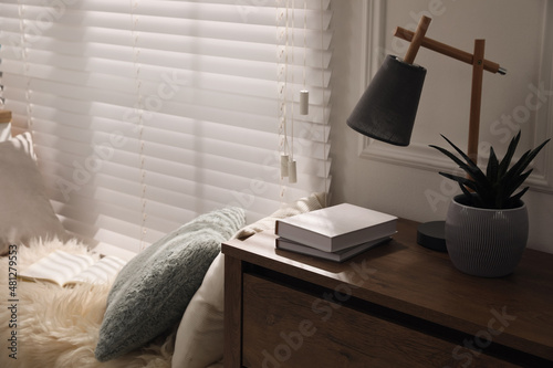 Foto Comfortable place for relax with faux fur and pillows near window in room