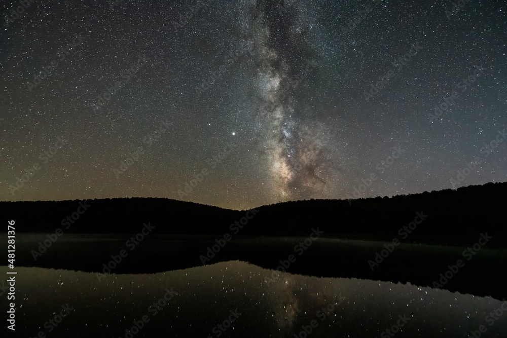 Night dark sky with milky way in Spruce Knob Lake West Virginia water