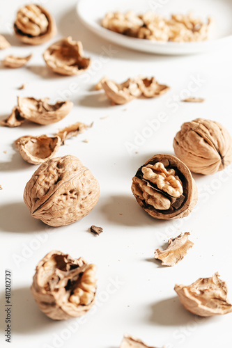 Cosy autumn aesthetic composition with dry leaves, walnuts on white background. Flat lay, top view, copy space.
