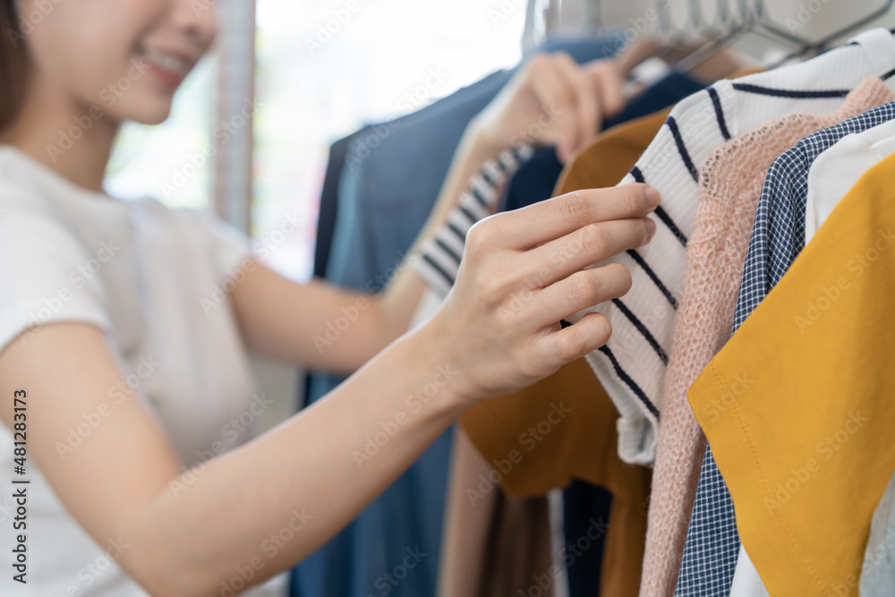 Obraz premium Choice of clothes, Nothing to wear asian young woman, girl hand in choosing dress, outfit on hanger in wardrobe in room closet at home. Deciding what to put on which one.