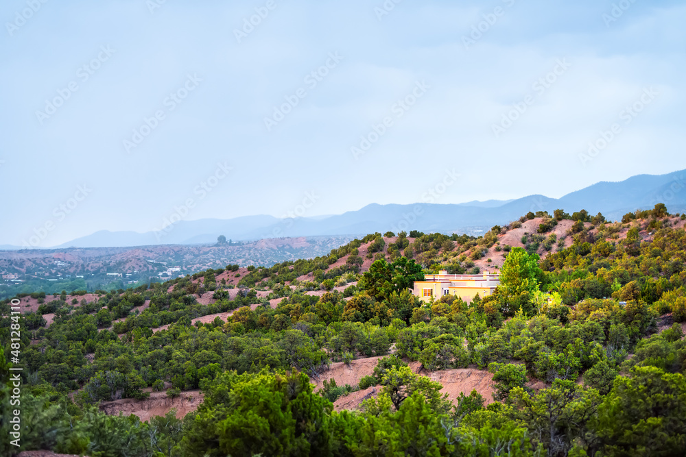 High desert mountain house home landscape aerial view during summer sunset and twilight blue hour in Santa Fe, New Mexico mountains in background