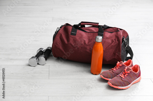 Sports bag and gym stuff on white floor photo