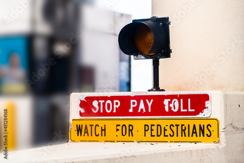 Red stop pay for toll watch for pedestrians sign text light on road interstate highway from Miami to Naples, Florida